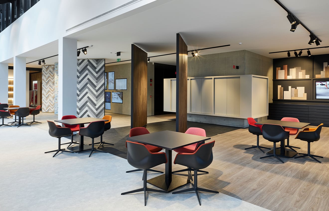 An office with pedestal tables and chairs in the middle of a large room.